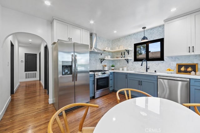 3556 Olive Ave, Long Beach, CA 90807 - kitchen featuring stainless steel appliances, a sink, wall chimney range hood, tasteful backsplash, and wood finished floors