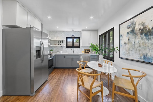 3556 Olive Ave, Long Beach, CA 90807 - kitchen with stainless steel appliances, a sink, tasteful backsplash, wood finished floors, and open shelves