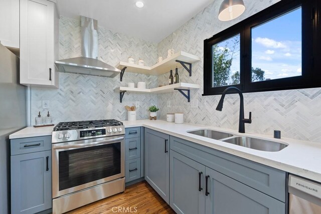 3556 Olive Ave, Long Beach, CA 90807 - kitchen featuring appliances with stainless steel finishes, wall chimney range hood, a sink, decorative backsplash, and light countertops