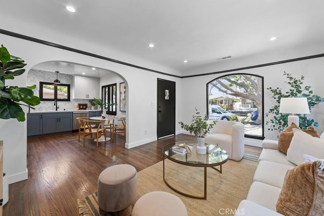 3556 Olive Ave, Long Beach, CA 90807 - living room featuring arched walkways, dark wood-style flooring, recessed lighting, and baseboards
