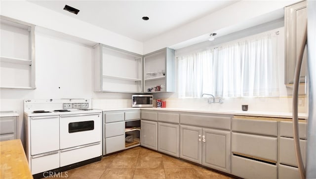529 E Harvard Pl, Ontario, CA 91764 - kitchen featuring white electric range oven, stainless steel microwave, open shelves, light countertops, and a sink