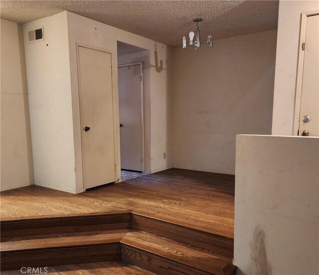 411 N Brannick Unit B, Los Angeles, CA 90063 - unfurnished room with wood finished floors, a textured ceiling, and a chandelier