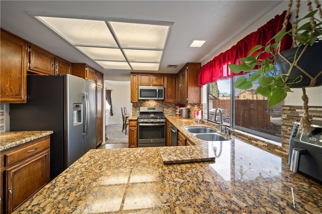 43816 Fallon Dr, Lancaster, CA 93535 - kitchen with stainless steel appliances, a sink, tasteful backsplash, and light stone countertops