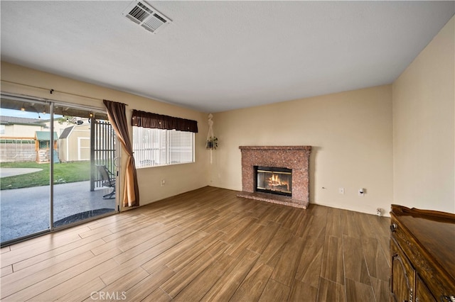 43816 Fallon Dr, Lancaster, CA 93535 - unfurnished living room with wood finished floors and a brick fireplace