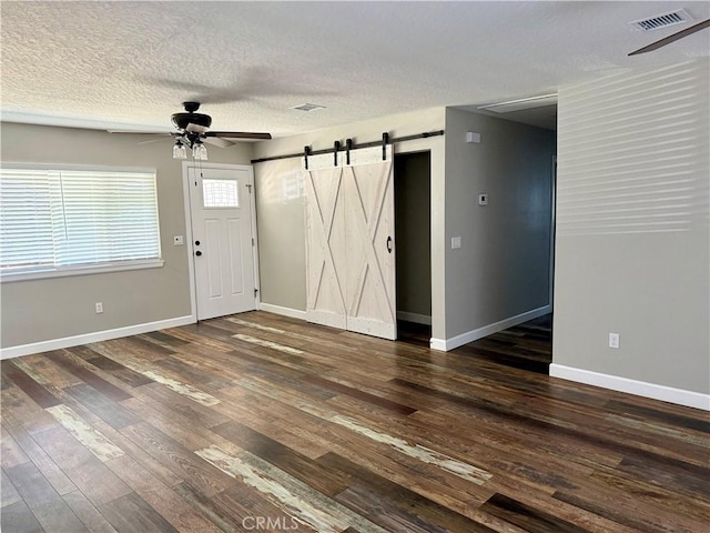 18083 Deodar St, Hesperia, CA 92345 - entrance foyer with ceiling fan, a barn door, dark wood-style floors, and a textured ceiling