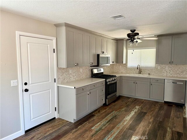 18083 Deodar St, Hesperia, CA 92345 - kitchen featuring stainless steel appliances, gray cabinets, a ceiling fan, dark wood finished floors, and tasteful backsplash