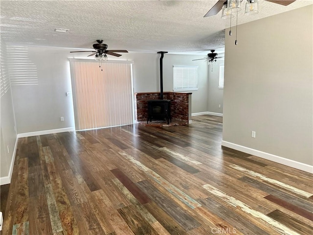 18083 Deodar St, Hesperia, CA 92345 - unfurnished living room with a ceiling fan, a textured ceiling, a wood stove, and wood finished floors