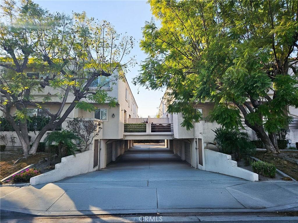 21409 Bloomfield Ave Unit C, Lakewood, CA 90715 - view of side of home featuring stucco siding, a carport, and driveway