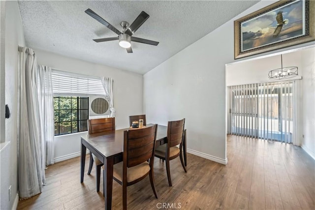 13883 Northstar Ave, Victorville, CA 92392 - dining space featuring vaulted ceiling, a chandelier, wood finished floors, a textured ceiling, and a ceiling fan