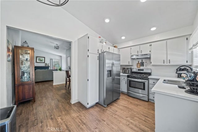 13883 Northstar Ave, Victorville, CA 92392 - kitchen featuring stainless steel appliances, vaulted ceiling, light countertops, under cabinet range hood, and wood finished floors