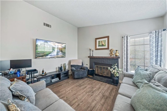 13883 Northstar Ave, Victorville, CA 92392 - living room with wood finished floors, a textured ceiling, and a fireplace