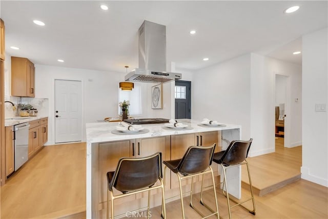 144 N Dommer Ave, Walnut, CA 91789 - kitchen featuring island exhaust hood, appliances with stainless steel finishes, light wood finished floors, a kitchen island, and decorative backsplash
