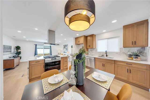 144 N Dommer Ave, Walnut, CA 91789 - kitchen with stainless steel appliances, a sink, island exhaust hood, light wood-type flooring, and decorative backsplash