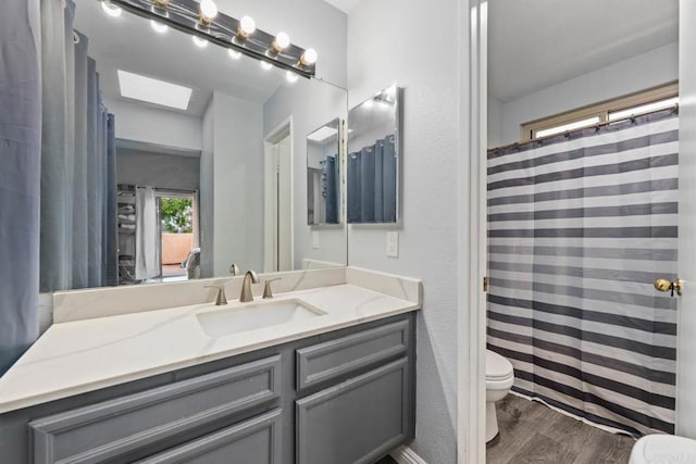 1380 E Washington Ave Unit 2, El Cajon, CA 92019 - bathroom with toilet, wood finished floors, vanity, and a skylight