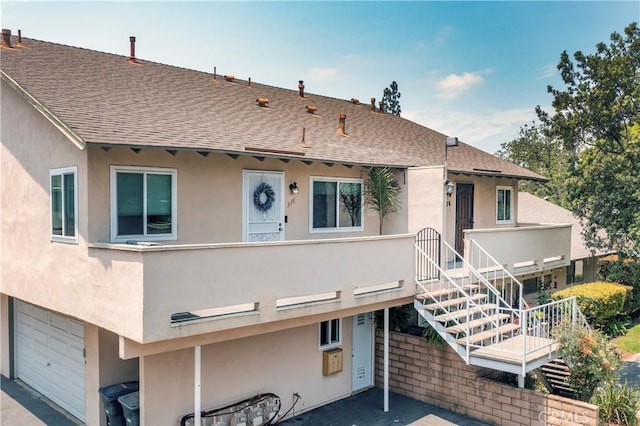 338 E Palmdale Ave Unit 4, Orange, CA 92865 - view of front of property featuring a shingled roof, a garage, stucco siding, and stairway