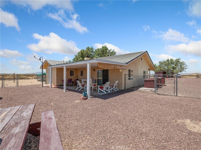 49333 Riverside Rd, Newberry Springs, CA 92365 - back of property featuring a gate, a patio area, a tiled roof, and stucco siding