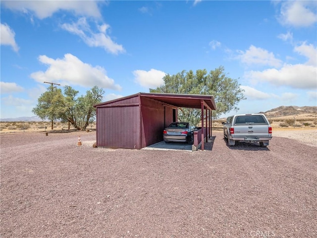 49333 Riverside Rd, Newberry Springs, CA 92365 - view of outdoor structure with a carport, driveway, and a mountain view