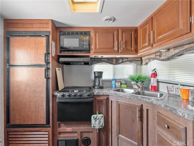 49333 Riverside Rd, Newberry Springs, CA 92365 - kitchen with black appliances, under cabinet range hood, brown cabinets, light countertops, and a sink