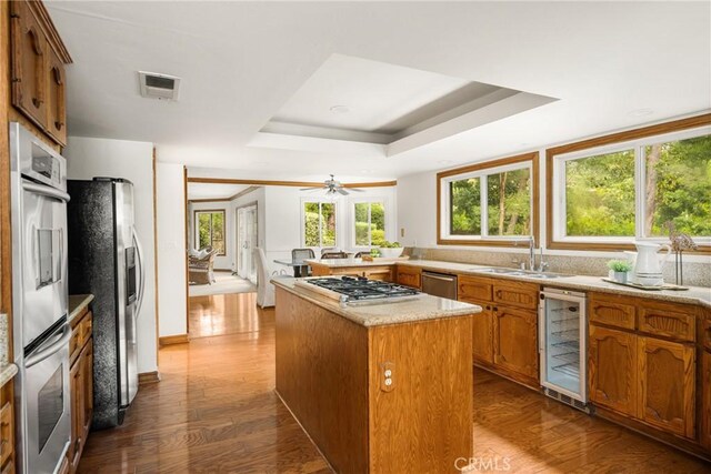 32022 Via Pavo Real, Coto De Caza, CA 92679 - kitchen with wine cooler, stainless steel appliances, a sink, brown cabinets, and a raised ceiling