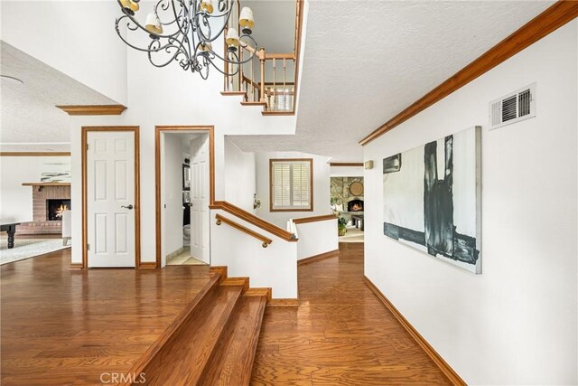32022 Via Pavo Real, Coto De Caza, CA 92679 - stairway featuring a fireplace, a textured ceiling, wood finished floors, crown molding, and baseboards