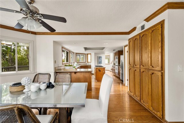 32022 Via Pavo Real, Coto De Caza, CA 92679 - dining space featuring ornamental molding, light wood finished floors, ceiling fan, and a textured ceiling