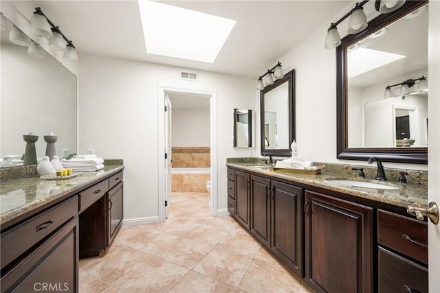 32022 Via Pavo Real, Coto De Caza, CA 92679 - full bathroom featuring double vanity, a skylight, a garden tub, tile patterned flooring, and baseboards