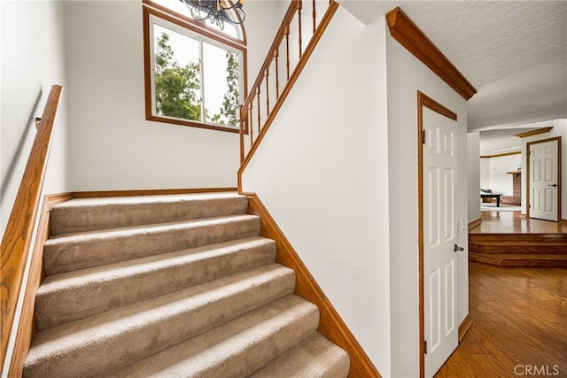32022 Via Pavo Real, Coto De Caza, CA 92679 - stairway featuring wood finished floors, a textured ceiling, and a chandelier