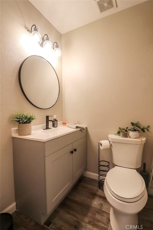1330 Santa Fe Cir, Needles, CA 92363 - half bath with vanity, baseboards, wood finished floors, and toilet