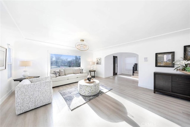 615 S Victoria Ave, Corona, CA 92879 - living room featuring arched walkways, baseboards, and light wood-style floors