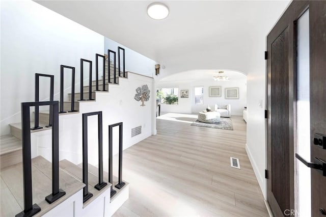 615 S Victoria Ave, Corona, CA 92879 - hall with arched walkways, stairs, light wood-style floors, and baseboards