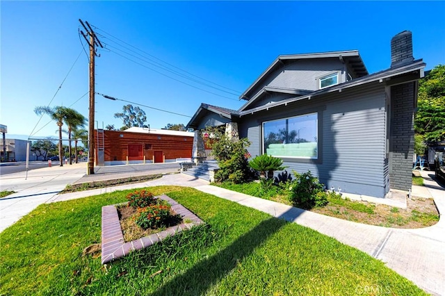 615 S Victoria Ave, Corona, CA 92879 - view of front of home featuring a front yard, a chimney, and brick siding