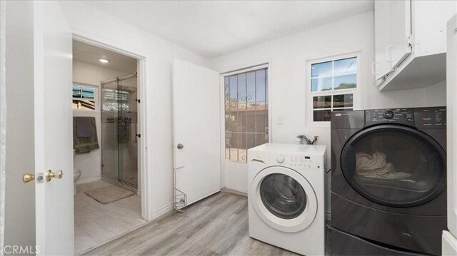 1373 W 5th St, San Bernardino, CA 92411 - washroom featuring cabinet space, washing machine and clothes dryer, and light wood-style floors