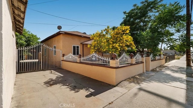 1373 W 5th St, San Bernardino, CA 92411 - view of home's exterior featuring a fenced front yard, stucco siding, and a gate