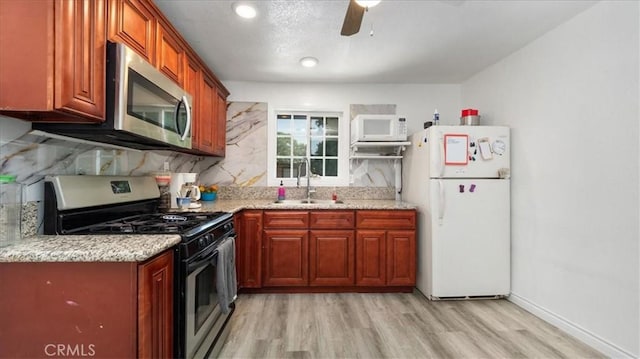 1373 W 5th St, San Bernardino, CA 92411 - kitchen featuring stainless steel appliances, a sink, ceiling fan, light wood-style flooring, and decorative backsplash
