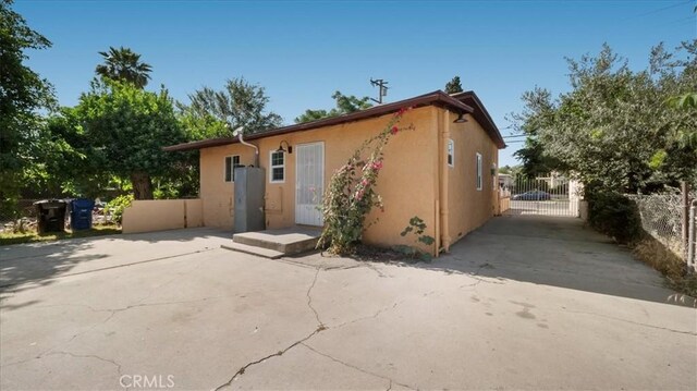 1373 W 5th St, San Bernardino, CA 92411 - rear view of house featuring stucco siding and a gate