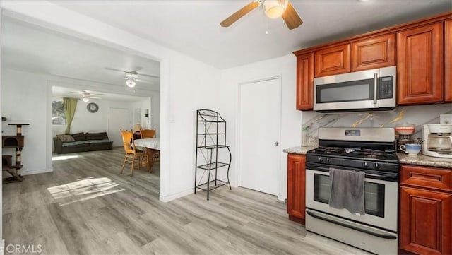 1373 W 5th St, San Bernardino, CA 92411 - kitchen with appliances with stainless steel finishes, ceiling fan, light wood finished floors, light stone counters, and baseboards