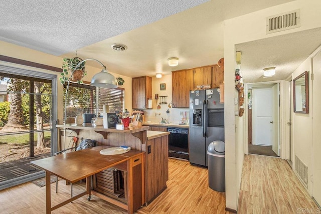 150 Richeth Rd, San Diego, CA 92114 - kitchen featuring stainless steel refrigerator with ice dispenser, black dishwasher, light wood-style floors, a textured ceiling, and brown cabinets