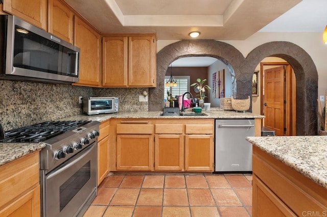 1663 Linda Sue Ln, Encinitas, CA 92024 - kitchen featuring stainless steel appliances, decorative backsplash, a raised ceiling, and arched walkways