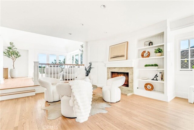 432 Holly St, Laguna Beach, CA 92651 - living room with light wood finished floors, plenty of natural light, a high end fireplace, and built in shelves