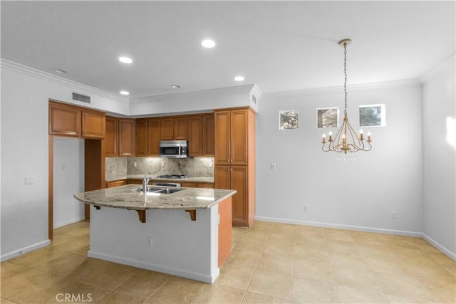 23795 Los Pinos Ct, Corona, CA 92883 - kitchen featuring stainless steel microwave, ornamental molding, a chandelier, tasteful backsplash, and light stone counters
