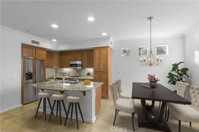 23795 Los Pinos Ct, Corona, CA 92883 - kitchen featuring stainless steel appliances, crown molding, a chandelier, backsplash, and a breakfast bar area