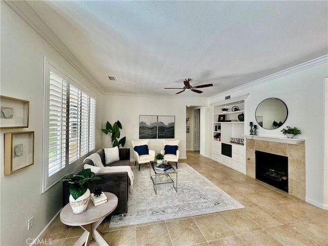 23795 Los Pinos Ct, Corona, CA 92883 - tiled living area featuring built in shelves, ceiling fan, crown molding, a tiled fireplace, and baseboards