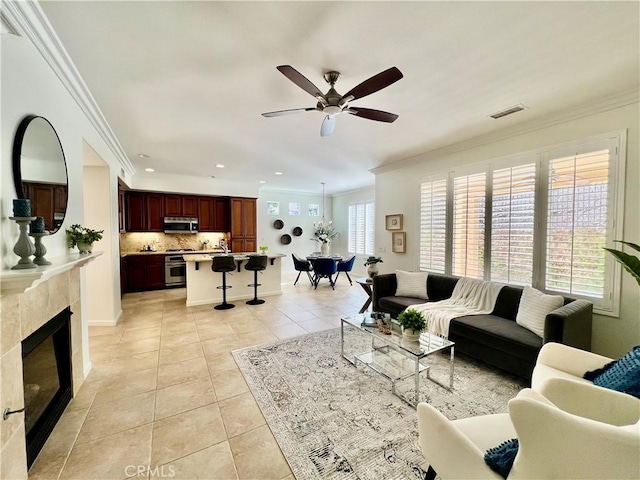 23795 Los Pinos Ct, Corona, CA 92883 - living room featuring light tile patterned flooring, crown molding, a ceiling fan, a tiled fireplace, and recessed lighting