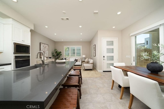 109 Pitch, Irvine, CA 92618 - kitchen featuring appliances with stainless steel finishes, white cabinets, recessed lighting, a kitchen breakfast bar, and open floor plan
