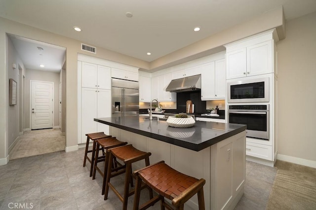 109 Pitch, Irvine, CA 92618 - kitchen with built in appliances, under cabinet range hood, dark countertops, white cabinets, and recessed lighting