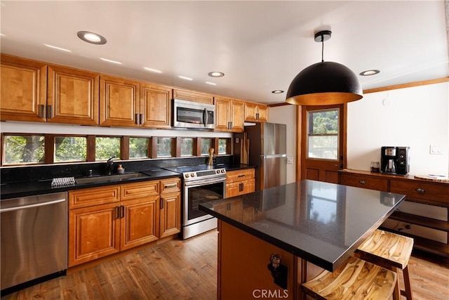 1370 Calgary Dr, Lake Arrowhead, CA 92352 - kitchen featuring appliances with stainless steel finishes, a sink, a kitchen bar, wood finished floors, and brown cabinets