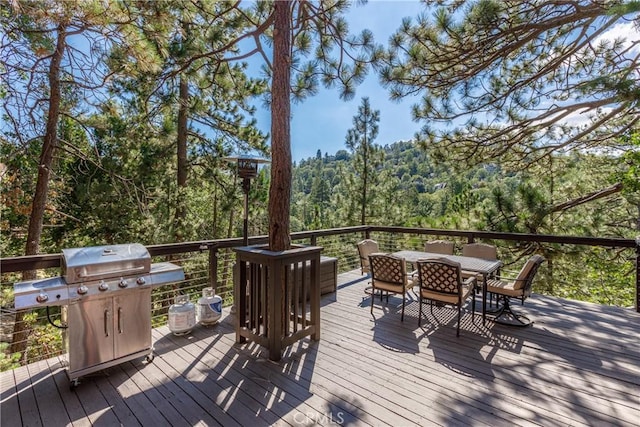 1370 Calgary Dr, Lake Arrowhead, CA 92352 - wooden terrace featuring a grill, outdoor dining area, and a forest view