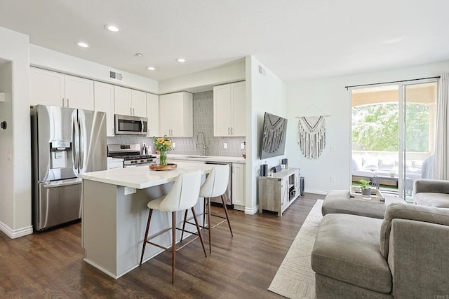 3171 Dehesa Rd Unit 3, El Cajon, CA 92019 - kitchen with appliances with stainless steel finishes, open floor plan, a sink, a breakfast bar, and decorative backsplash