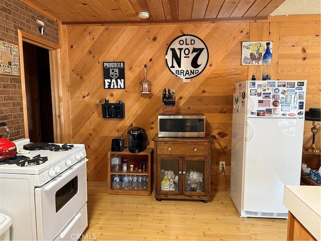 98011 Maine Rd, Kennedy Meadows, CA 93527 - kitchen featuring white appliances, light wood-type flooring, wooden ceiling, brick wall, and wooden walls