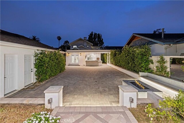 1281 E Orange Grove Blvd, Pasadena, CA 91104 - view of front facade with an outdoor fire pit, a patio area, french doors, and driveway